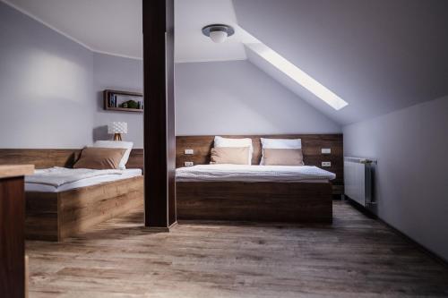 a bedroom with two beds and a slanted ceiling at Penzion Prestige Tennis Park in Frýdek-Místek