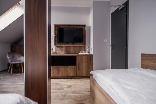 a bedroom with a bed and a television in it at Penzion Prestige Tennis Park in Frýdek-Místek