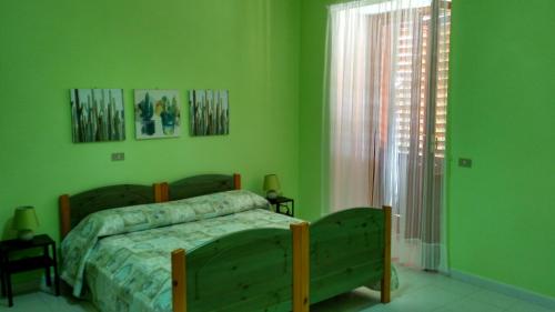 a green bedroom with a bed and a window at La Magnolia sul Lago in Campolattaro