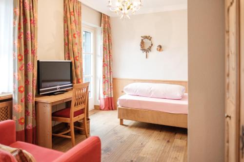 a bedroom with a bed and a tv in a room at Landhaus am Stein in Bad Wiessee