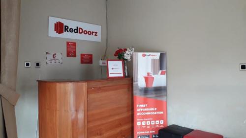 una señal de puerta roja en una pared de una habitación en RedDoorz Syariah near Universitas 17 Agustus Banyuwangi, en Banyuwangi
