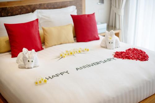 a bed with two white rabbits and flowers on it at Beach Republic Koh Samui in Lamai
