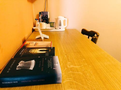 zwei Bücher auf einem Holztisch in der Unterkunft Locanda Piemonte da Sciolla in Domodossola