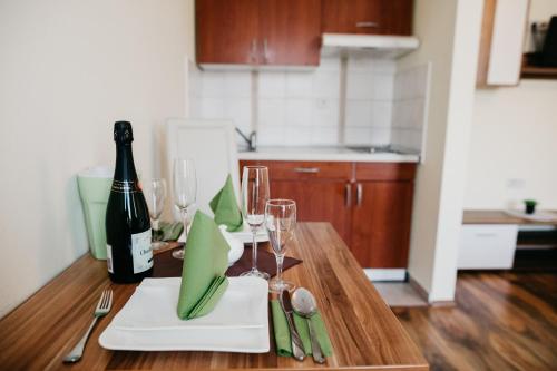 a table with a bottle of wine and glasses on it at Apartments-rooms Vogrinec in Ptuj