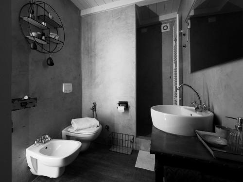 a bathroom with a toilet and a tub and a sink at Light Blue Lake Aria in Argegno