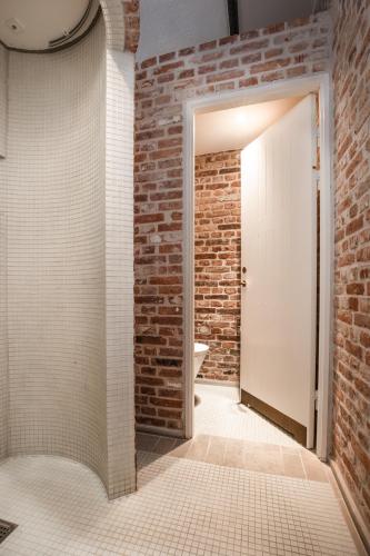 a bathroom with a brick wall and a white door at Hindsgavl Slot in Middelfart
