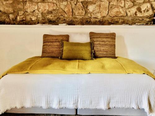 a white bed with two pillows on top of it at Le Jardin d'Emile in Cassis