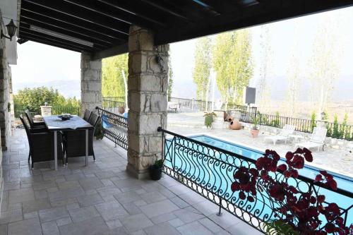 a patio with a table and a swimming pool at Lasa Black Rock villa in Paphos City