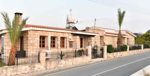 a stone house on the side of a street at Lasa Black Rock villa in Paphos City