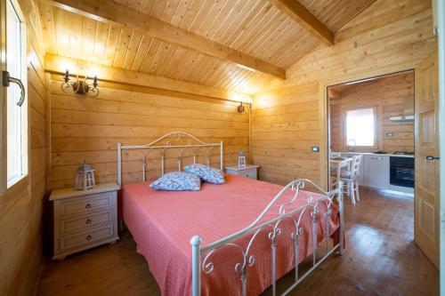 a bedroom with a bed in a wooden room at Chalet Tenuta Lacco in Furnari