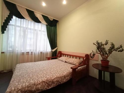 een slaapkamer met een bed, een tafel en een raam bij Квартира на Данилевского in Charkov