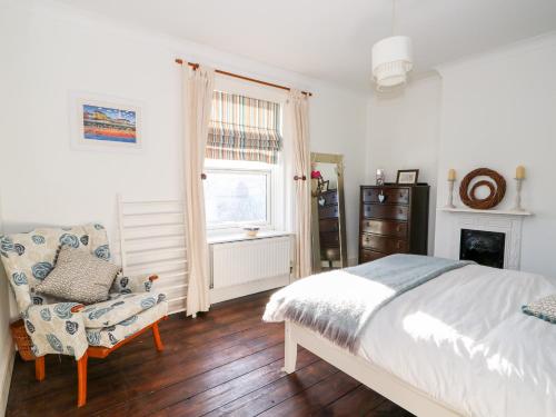 une chambre avec un lit, une chaise et une fenêtre dans l'établissement Carrstone Cottage, à Heacham