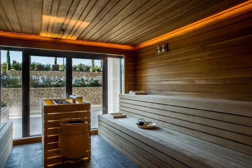 a sauna with wooden walls and a large window at Coquillade Provence - Relais & Châteaux in Gargas
