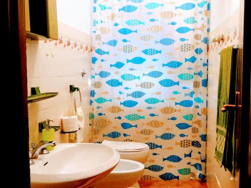 een badkamer met een toilet en een douchegordijn met vissen bij Casa Nancy in Palizzi Marina