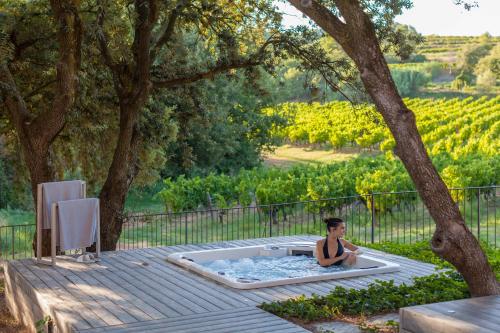 a boy sitting in a hot tub under a tree at Coquillade Provence - Relais & Châteaux in Gargas
