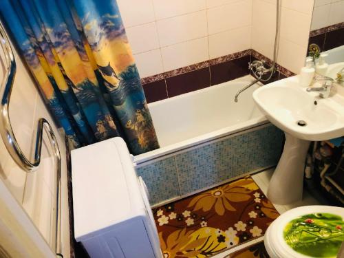 a bathroom with a sink and a tub and a toilet at Apartment on Revolutsii 26 studia in Perm
