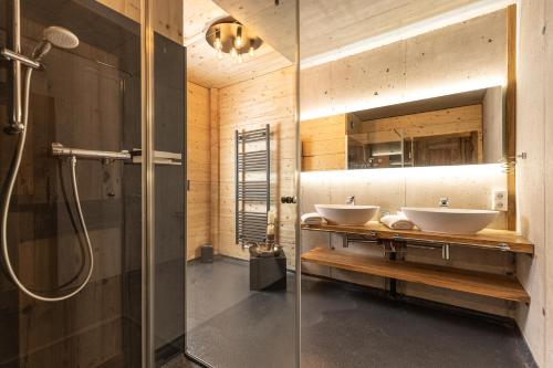 a bathroom with two sinks and a shower at Naturlodge Tirol - Naturverbunden im Zillertal in Fügen
