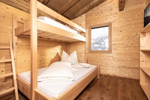 a bedroom with bunk beds in a wooden cabin at Naturlodge Tirol - Naturverbunden im Zillertal in Fügen
