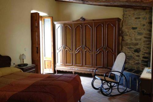 1 dormitorio con 1 cama grande de madera y 1 silla en Can Frencis, en Osor