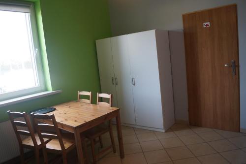 a kitchen with a wooden table and a white refrigerator at Noclegi u Matyldy in Marklowice