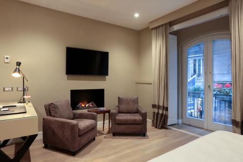 pokój hotelowy z kominkiem i 2 krzesłami w obiekcie Caruso Place Boutique & Wellness Suites w mieście Neapol