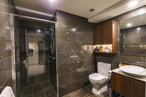 un bagno con doccia, WC e lavandino di Hamptons Retreat on Level 77 Skytower a Brisbane