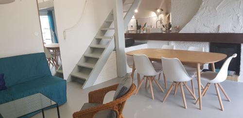 une salle à manger et une cuisine avec une table et des chaises dans l'établissement Les pieds dans le sable, au Cap d'Agde