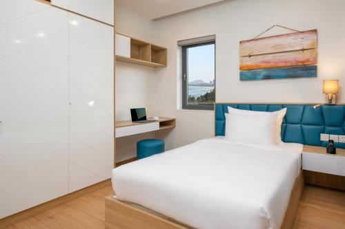 a bedroom with a bed and a window at Dolphin Hotel and Apartment in Da Nang
