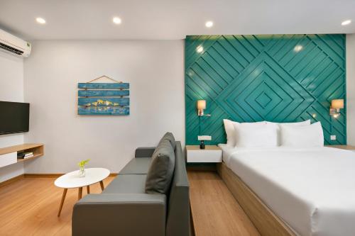 a bedroom with a bed and a couch and a tv at Dolphin Hotel and Apartment in Da Nang