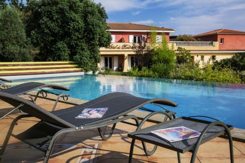 a group of chairs sitting next to a swimming pool at Hotel du Pont de l'Oso in Cala Rossa