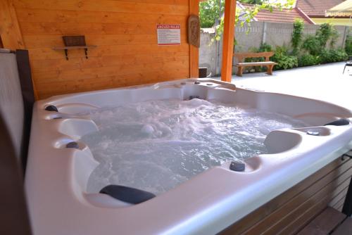 a large bath tub filled with water in a backyard at Pension Nest - Family Apartman in Mosonmagyaróvár