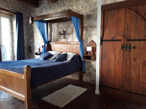 a bedroom with a wooden bed and a wooden door at Chambres d'hôtes l'Escuelle des Chevaliers in Cordes-sur-Ciel