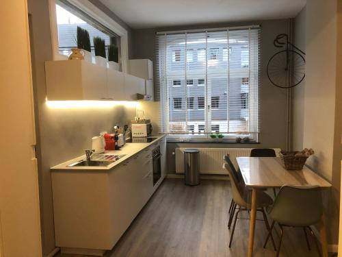 a kitchen with a sink and a table and a window at Claire et Liège, toute une histoire... in Liège