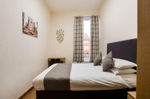 1 dormitorio con cama y ventana en The New Mill Apartments, en Newcastle