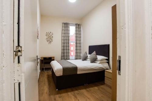 1 dormitorio con cama y ventana en The New Mill Apartments, en Newcastle