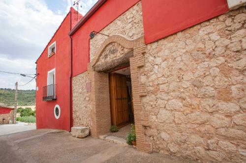 un edificio rojo con una gran puerta. en Los Nidos de Rebollosa en Rebollosa de Hita