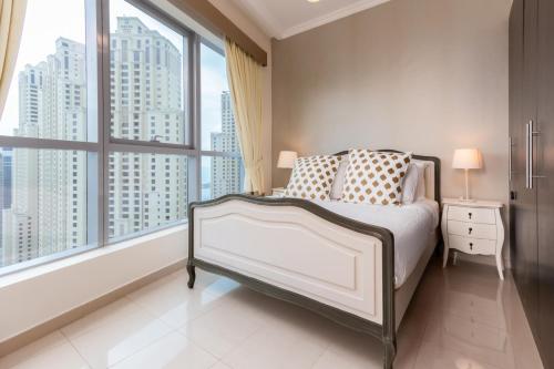 1 dormitorio con cama y ventana grande en Quintessential Quarters - Breathtaking 29th Floor Views, en Dubái