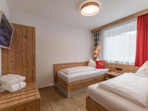 a hotel room with two beds and a window at Echt Woods Appartements in Söll