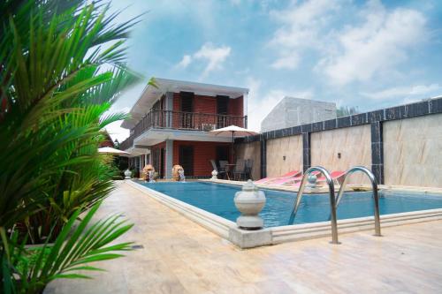 a swimming pool in front of a house at D Family Resort in Anuradhapura