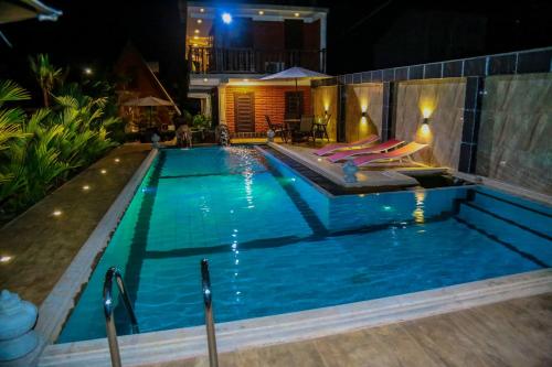 a swimming pool at night with a resort at D Family Resort in Anuradhapura