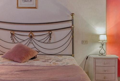 a bed with a pink pillow on it in a bedroom at Agriturismo La Colmata in Cesa