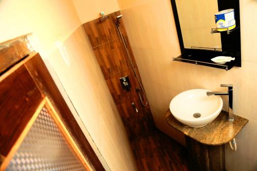 a bathroom with a white sink and a mirror at D Family Resort in Anuradhapura