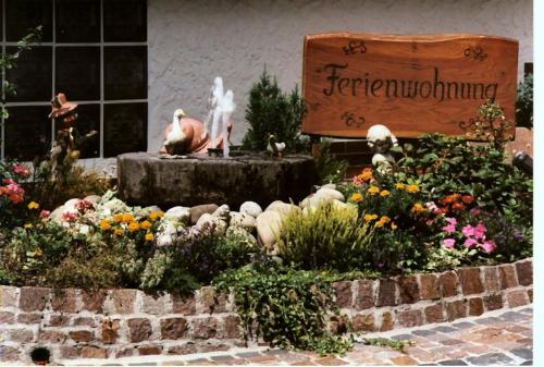 a garden with a fountain in front of a sign at Muehle-Maus in Sankt Goarshausen