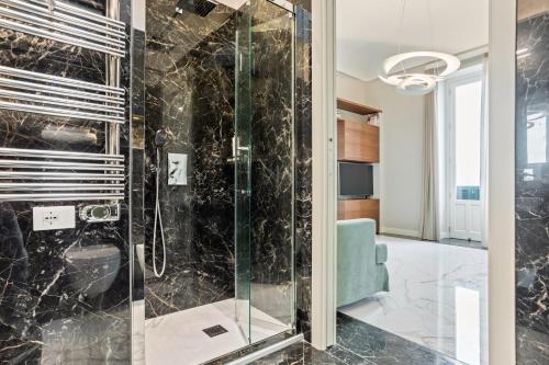 baño con ducha y puerta de cristal en Darsena Apartments by Wonderful Italy, en Siracusa