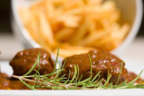 a plate of food with meatballs and french fries at My Way Luxury Ibiza Studio - AB Group in Playa d'en Bossa