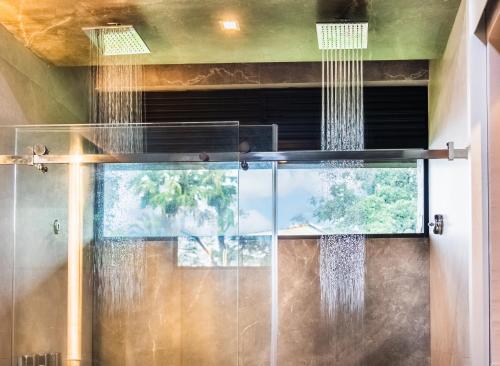 a shower in a bathroom with raindrops on the window at Noah's Forest Hotel by Tifakara in Fortuna