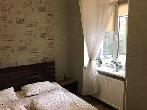 een slaapkamer met een bed en een raam bij Hostel Q ,15 хв до жд вокзалу in Lviv