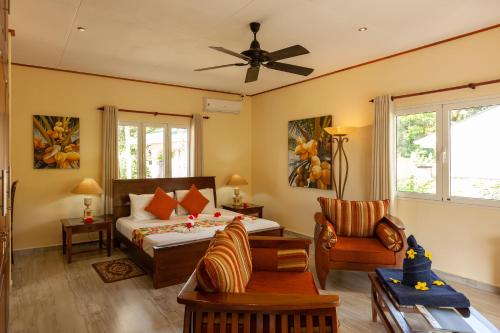 a bedroom with a bed and a living room at Villa Aya in Grand'Anse Praslin