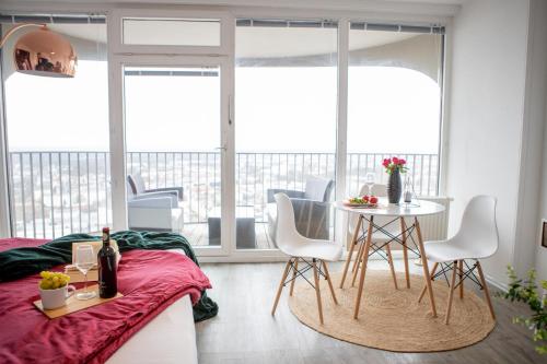 een kamer met een bed en een tafel en stoelen bij Modernes Apartment mit tollem Blick über die Stadt in Augsburg