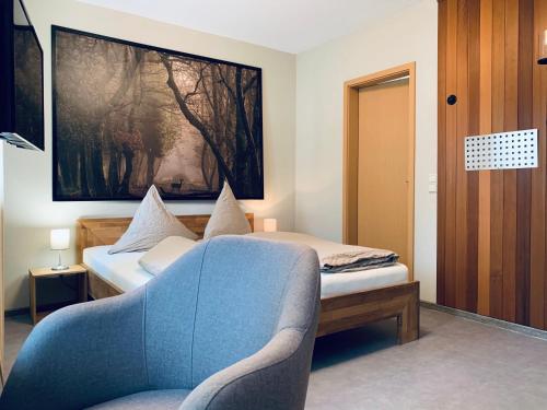 a small room with a bed and a chair at Hotel-Bistro-Europa in Merchweiler